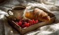 A tray of croissants and berries sits on a bed Royalty Free Stock Photo