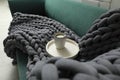 Tray with cup of coffee and soft chunky knit blanket on sofa indoors Royalty Free Stock Photo