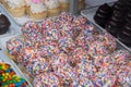 Tray of decorated vanilla cupcakes with white frosting and rainbow sprinkles. There are chocolate cupcakes with chocolate frosting Royalty Free Stock Photo