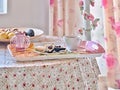 A tray with delicate pastel colors, on it a plate with avocado halves and toast