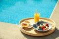 Tray with delicious breakfast near swimming pool Royalty Free Stock Photo