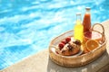 Tray with delicious breakfast near swimming pool. Space for text Royalty Free Stock Photo