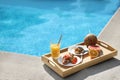 Tray with delicious breakfast near swimming pool. Space for text Royalty Free Stock Photo