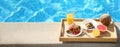 Tray with delicious breakfast near swimming pool, space for text. Banner design Royalty Free Stock Photo