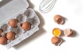 Tray of fresh raw eggs and broken egg shell on white isolated background. Royalty Free Stock Photo