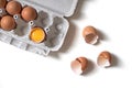 Tray of fresh raw eggs and broken egg shell on white isolated background. Royalty Free Stock Photo