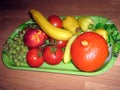 On the tray lies a harvest of tomatoes, bananas, grapes, peaches and peppers