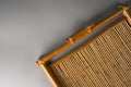 A tray made entirely of bamboo on a gray background.