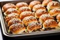 a tray of mixed bbq sliders with sesame seeds topping