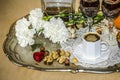 Tray of nickel silver with a bouquet of carnations, black coffee,old crystal glasses and a bottle of liquor Royalty Free Stock Photo