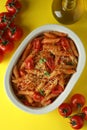 Tray with pasta with tomato sauce and ingredients on yellow background, top view Royalty Free Stock Photo