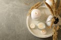 Tray with scented candles and reed on gray table Royalty Free Stock Photo