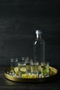 Tray with shots and bottle of vodka on wooden background Royalty Free Stock Photo