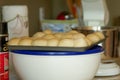 Tray of soft rolls ready for consumption in cluttered kitchen