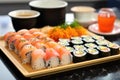 a tray of sushi next to a small bowl of pickled ginger Royalty Free Stock Photo