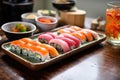 a tray of sushi next to a small bowl of pickled ginger Royalty Free Stock Photo