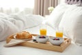 Tray with tasty breakfast on bed Royalty Free Stock Photo