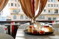 Tray with a teapot, cups and cakes on a table in a cafe against the window