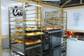 Trays with fresh baked rolls on a trolleys, electric oven, mini bakery production hall