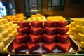 Trays full of stack colorful red velvet Indian sweet dessert in bakery showcase