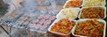 Trays of peppers and onions and grills with burgers Royalty Free Stock Photo