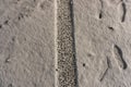 Tread marks on fresh snow. Track from car tire. Road covered with a thin layer of snow. Human footprints