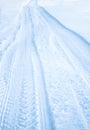 Tread texture of car wheels on snow. Winter road in January, December. Rural area and background of tractor tracks in the snow Royalty Free Stock Photo