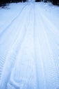 Tread texture of car wheels snow. Winter road in January, December. Rural area and background of tractor tracks in the snow Royalty Free Stock Photo