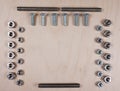 Treaded fasteners bolts and nuts at wooden background with copy space for your own text Royalty Free Stock Photo