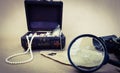 a treasure chest and an old map, a magnifying glass and binoculars. there are pearls and shells in the box. background Royalty Free Stock Photo