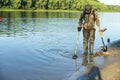 Treasure hunter is looking for a metal detector in the river Royalty Free Stock Photo