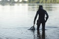 Treasure hunter is looking for a metal detector in the river Royalty Free Stock Photo