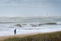 a treasure hunter with metal detector on storm on the beach