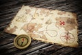 Treasure map and vintage compass standing on old wood table. 3D illustration Royalty Free Stock Photo
