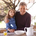 He treasures his granddaughter. Portrait of a little girl and her grandfather having breakfast together outside. Royalty Free Stock Photo