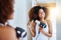 Treating her hair with care. an attractive young woman drying her hair with a hairdryer at home. Royalty Free Stock Photo