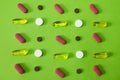 A treatment for ailment. Studio shot of an assortment of medication against a green background.