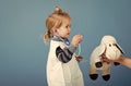 Treatment of children. Boy play veterinarian with toy sheep in mothers hand