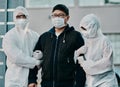 Treatment starts today. Shot of a young man getting taken away by healthcare workers in hazmat suits during an outbreak.