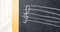 Treble clef on a chalkboard drawn by a child, chalk drawing, object detail, closeup, front view, nobody. Music, violin clef