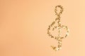 Treble clef made of golden small stars on a yellow background.