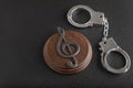 Treble clef sign and handcuffs. Illegal use of someone elses music. Copyright infringement. Music Licensing