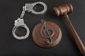Treble clef sign and handcuffs. Illegal use of someone elses music. Copyright infringement. Music Licensing