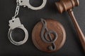 Treble clef sign and handcuffs. Illegal use of someone elses music. Punishment for intellectual property infringement. Music