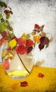 Tree branches with autumn yellow and red leaves in a glass vase. Butterfly on a leaf. Still life on textured old paper background Royalty Free Stock Photo