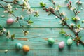 Tree Branches with Flowers and Easter Eggs on Mint Wooden Table Royalty Free Stock Photo
