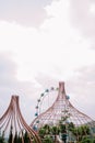 A tree cage and Ferris wheel with a backdrop of slightly cloudy skies Royalty Free Stock Photo