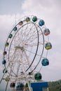 A tree cage and Ferris wheel with a backdrop of slightly cloudy skies Royalty Free Stock Photo