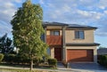 A tree in front of a brick home in the suburbs Royalty Free Stock Photo