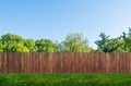 Tree in garden and wooden backyard fence with grass